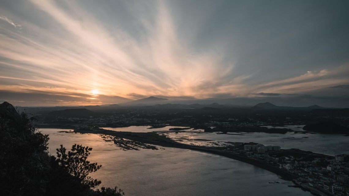 Captivating sunrise view over Seongsan, Jeju Island with striking seascape and clouds.