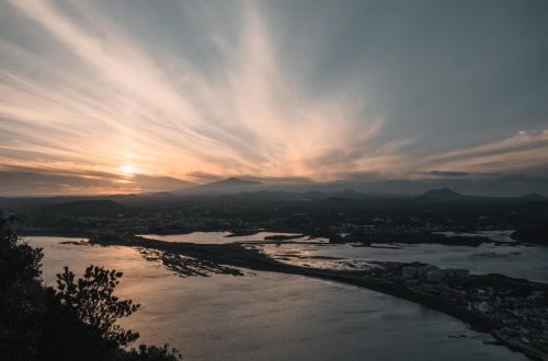 Captivating sunrise view over Seongsan, Jeju Island with striking seascape and clouds.